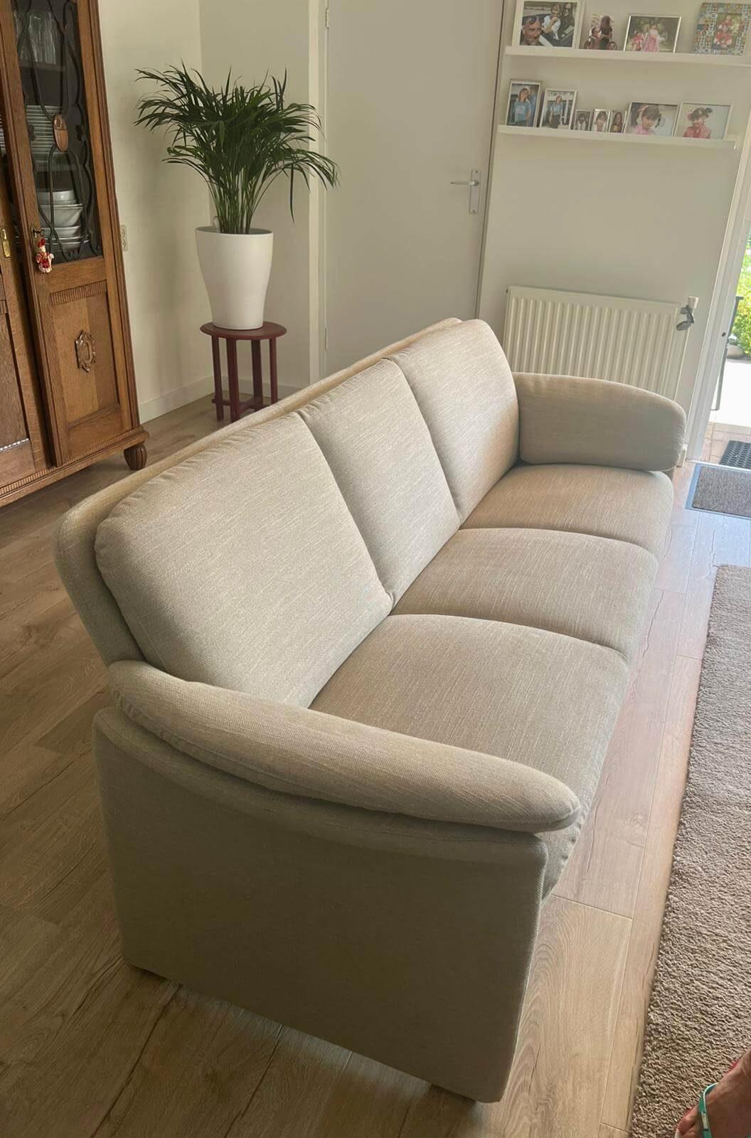 Lichte driezitsbank in stof in een woonkamer