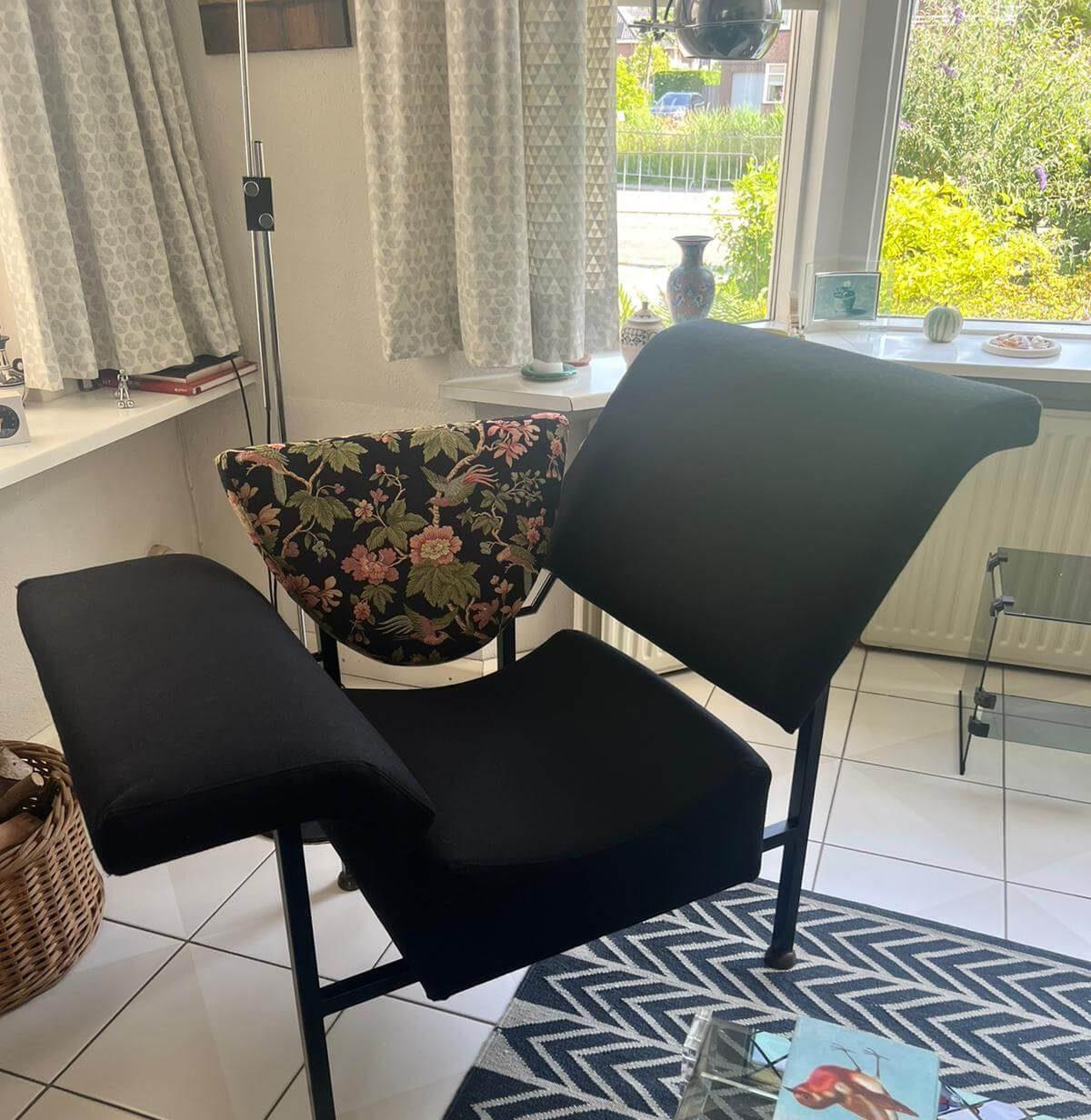 Zwarte fauteuil met een rugleuning in bloemenstof