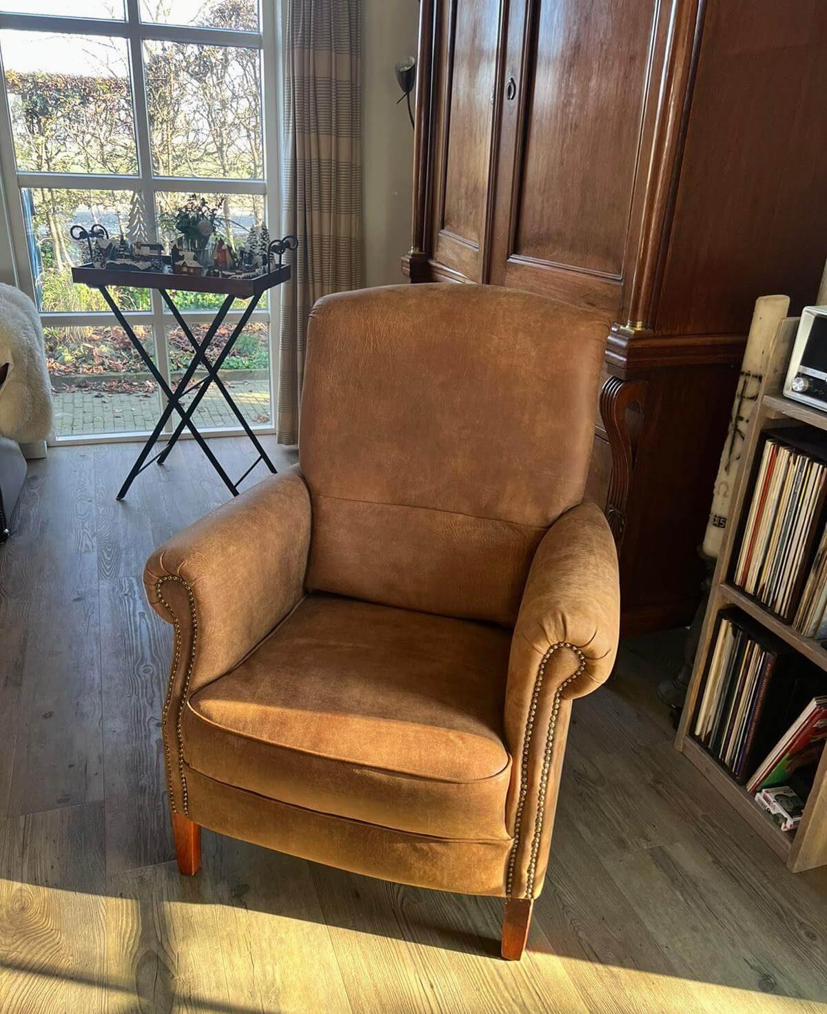 Cognackleurige leren fauteuil met sierspijkers langs de armleuningen